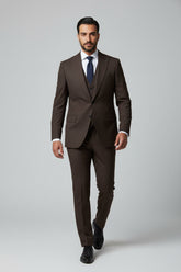 Man wearing brown slim fit three-piece suit with tailored vest and tie.